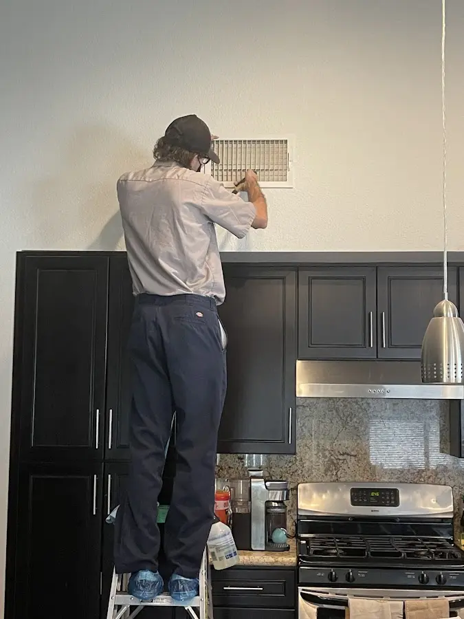 Technician inspecting an air vent during HVAC service in Chesterfield